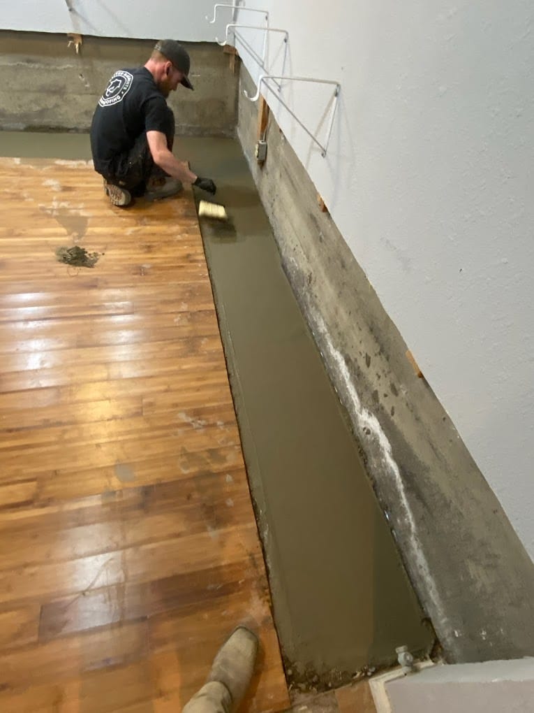Man smoothing concrete in basement