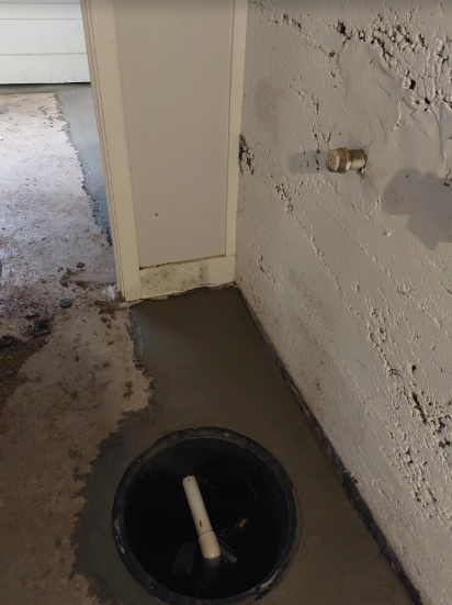 Sump pump placed in wet cement in basement