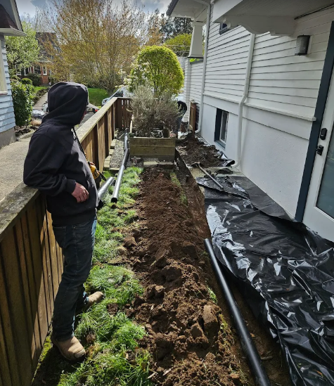 Worker installing outdoor waterproofing drain