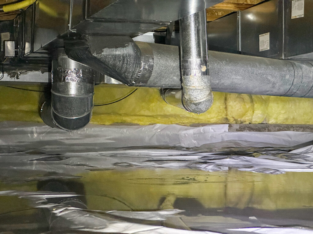 A water leak in a crawlspace with standing water on the vapor barrier