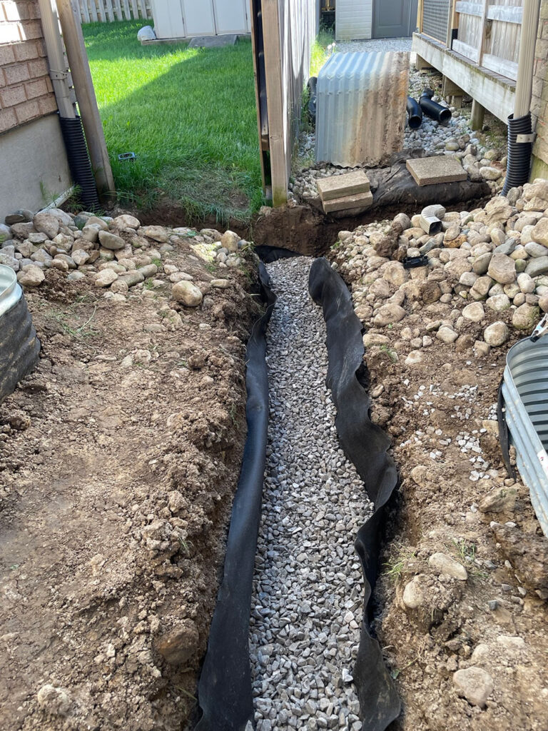 French drain installation with gravel and perforated pipe in Portland Oregon yard